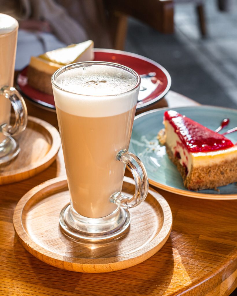 Classic New York Cheesecake And Coffee Latte on a table in cafe. Top view.